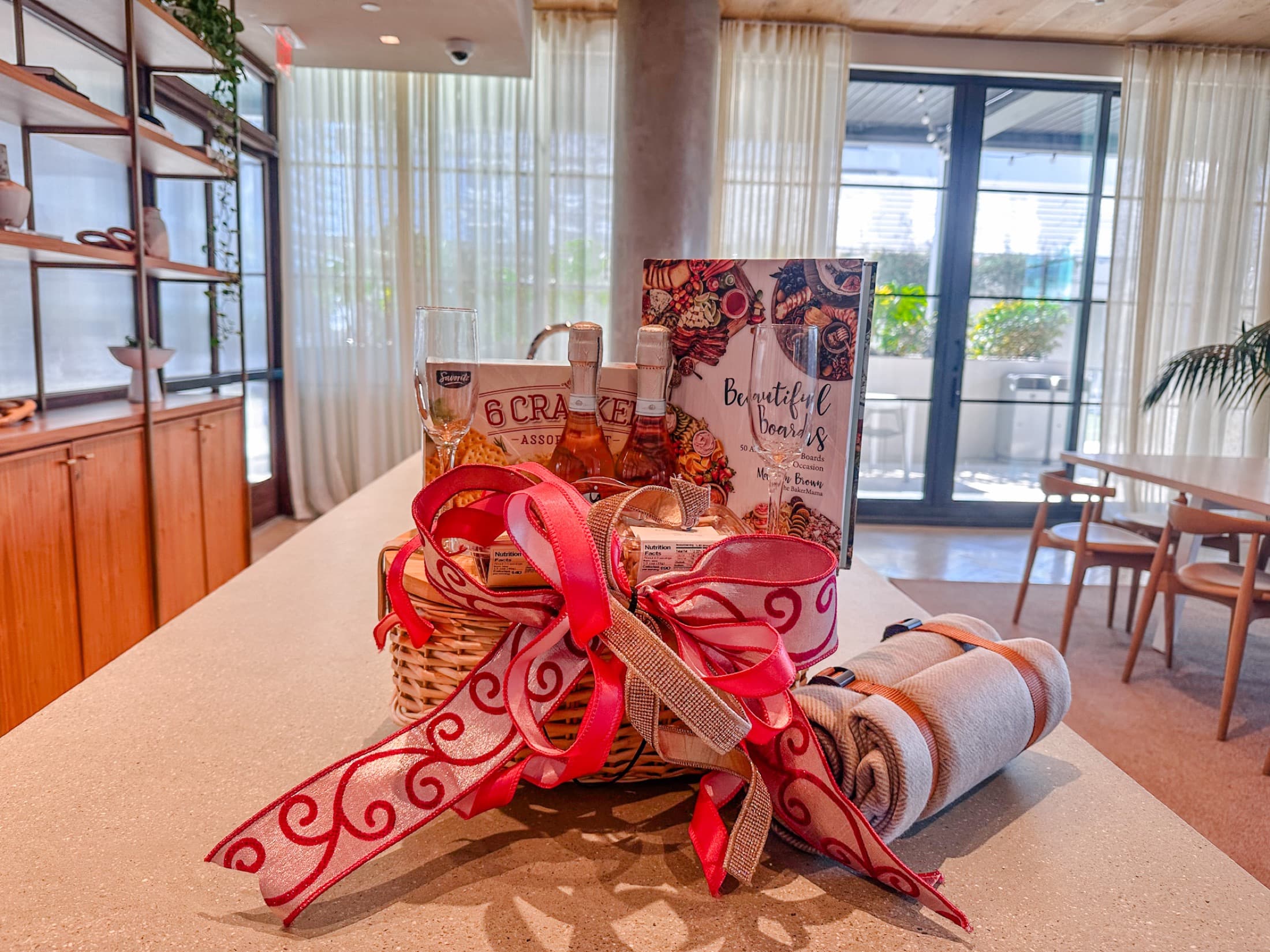 Large pink ribbon and wrapped holiday gifts arranged on a bright tabletop.